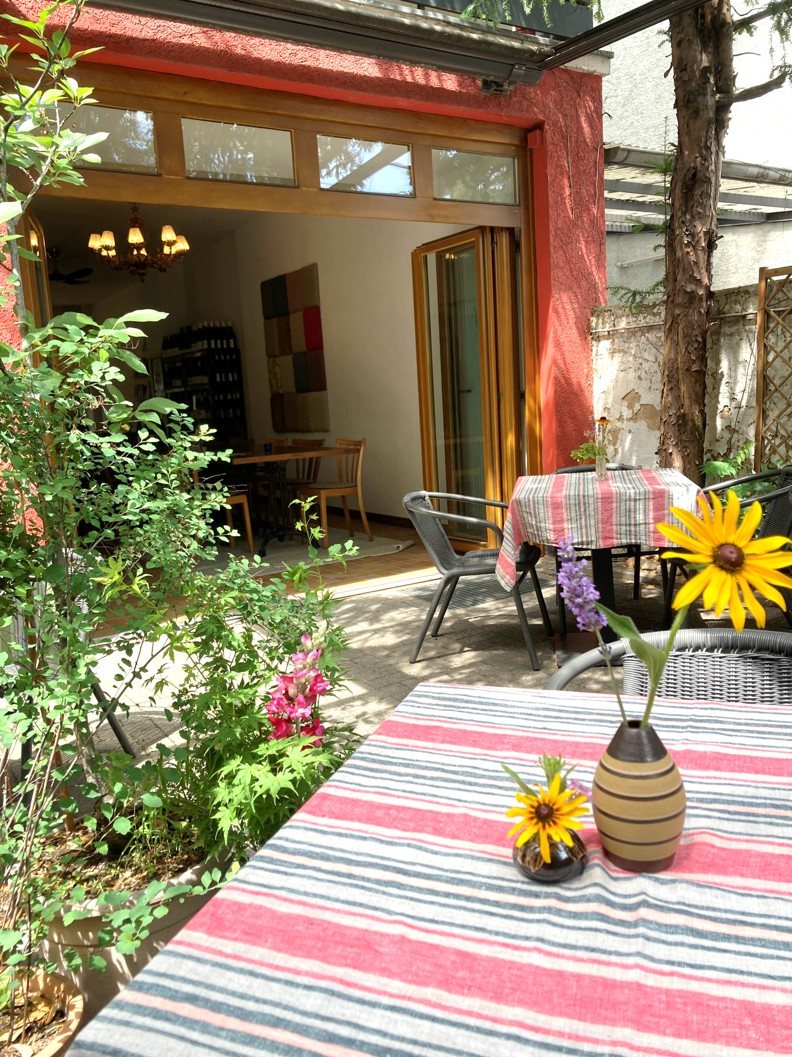 Offene Flügeltüren zwischen Garten und Innenraum bei Hase und Wolfshund